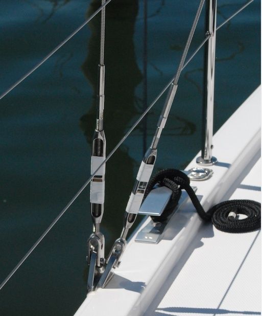 Vantskruvar och vajrar på en vit segelbåtsdäck